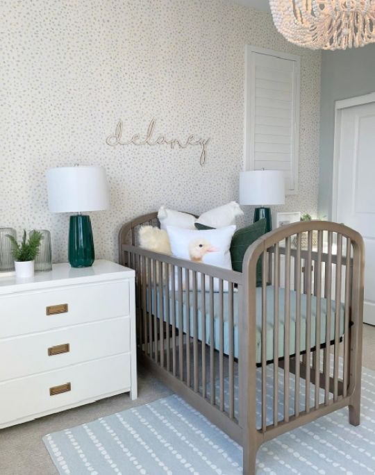 Neutral themed nursery with dotty wallpaper